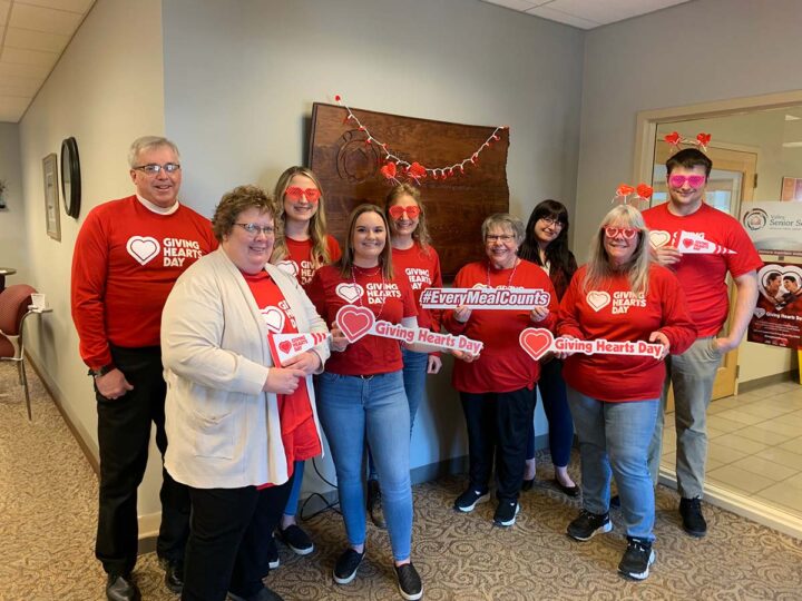 9 people wearing giving hearts day shirts